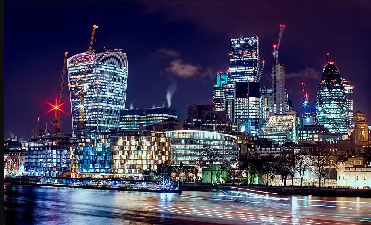 LUPC - Scope London city skyline at night with illuminated buildings and reflections on the river.