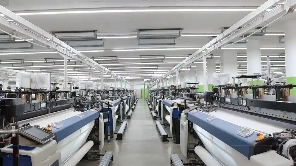 Rows of textile machines in a brightly lit modern factory.