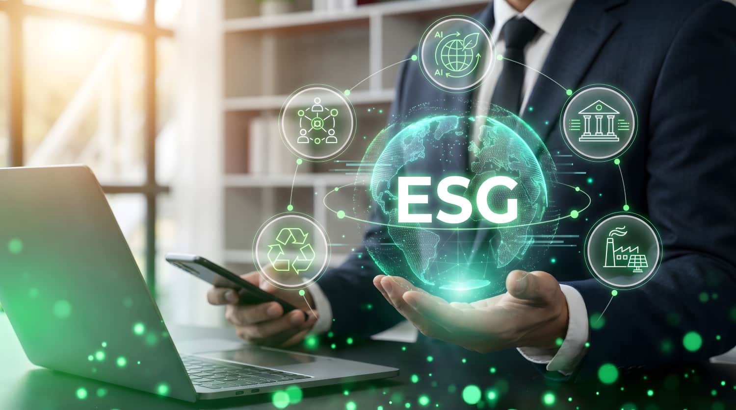 Corporate professional holding glowing ESG globe interface showcasing environmental social and governance business sustainability strategy. A person in a suit holds a phone by a laptop, with a glowing ESG graphic and green icons.